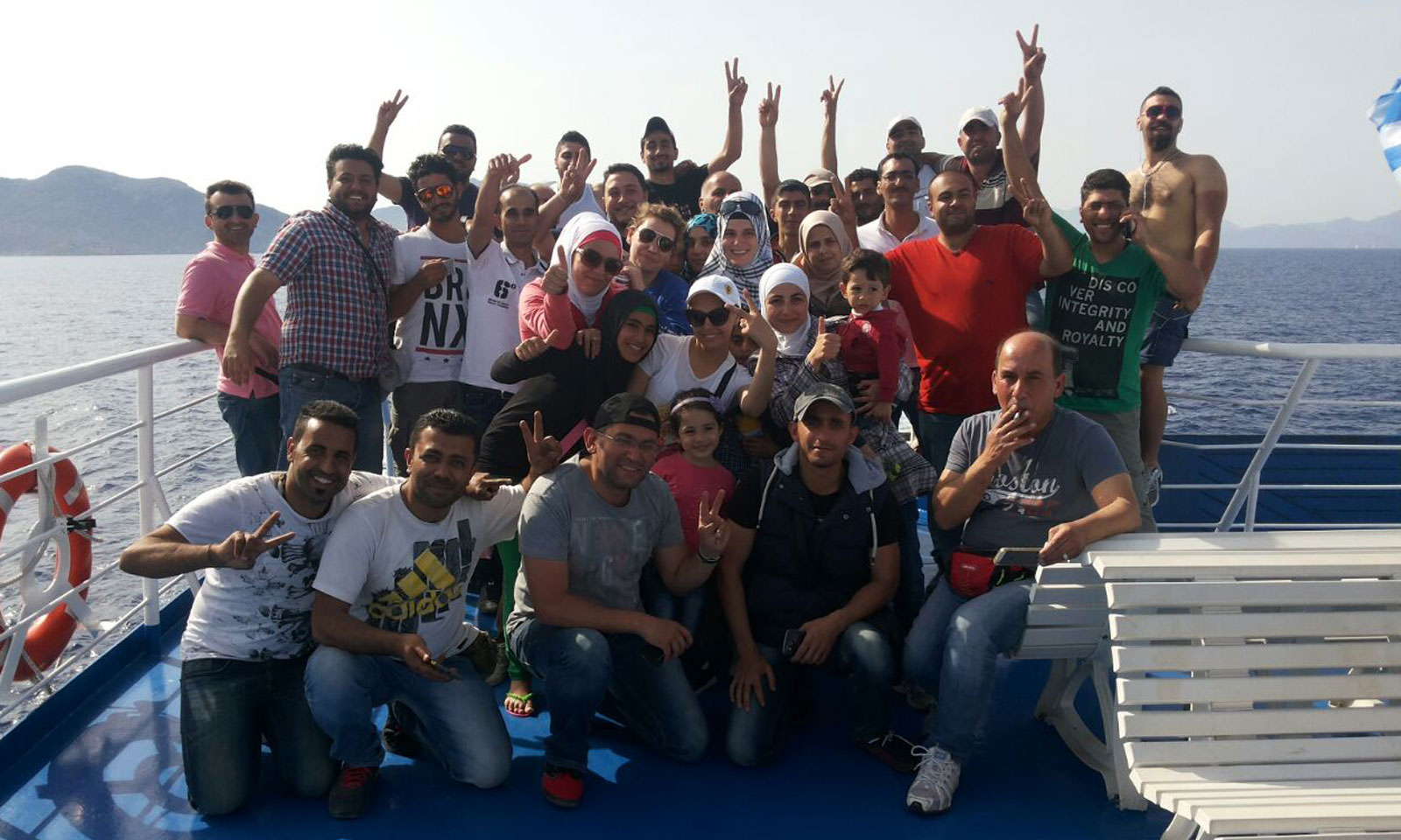 “صورة لركّاب البلم مع (أم محمد) بعد إنقاذهم من قبل خفر السواحل اليوناني​“